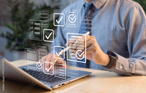 Business performance tracking concept. Businessman using tablet and laptop, completing digital survey form, online checklist, and audit for data analysis and reporting