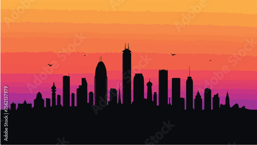 Silhouette of city skyline at sunset with flying birds beautiful gradient colors