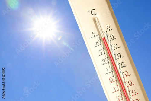 Extremely high temperature on thermometer against blue sky on sunny day. Summer weather