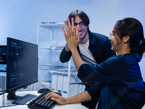 Diverse AI Programmers, Software developer Reviewing Machine Learning Code and Editing Prompt for Ai Chatbot Development Reviewing Code and Diagrams Together working together in Tech Office Workspace.