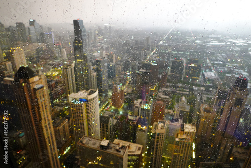 Highrise Buildings or Skyscrapers in Big City During Rainstorm with Rain Drops on Window