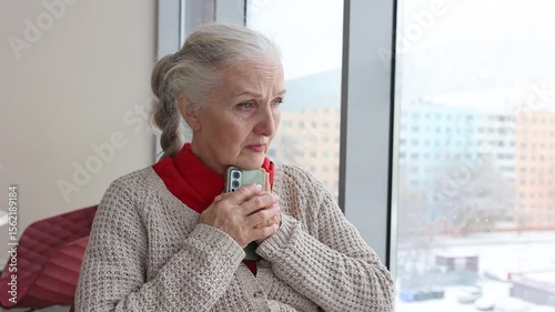 A sad senior woman received bad news on the phone
