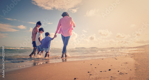 Asian family vacation holiday on the beach in the sunset