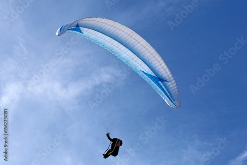 Paraglider flying in a blue sky	