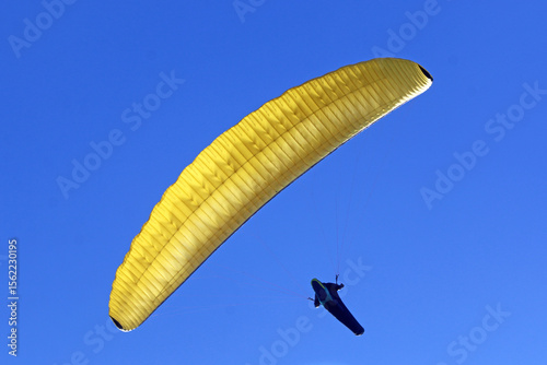 Paraglider flying in a blue sky	