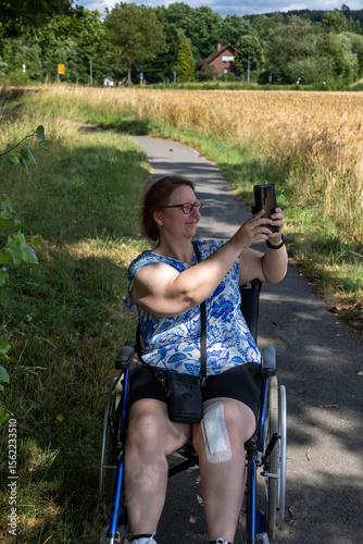 Mobility and technology: Woman in wheelchair uses smartphone for photo shoot