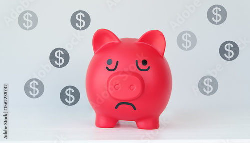 A red piggy bank with a sad face and a bunch of dollar coins