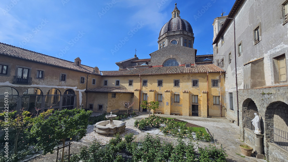Obraz premium Monastery Courtyard with Fountain and Flower Garden
