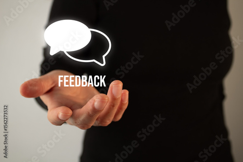 Woman's hand holding a speech bubble icon with the word feedback