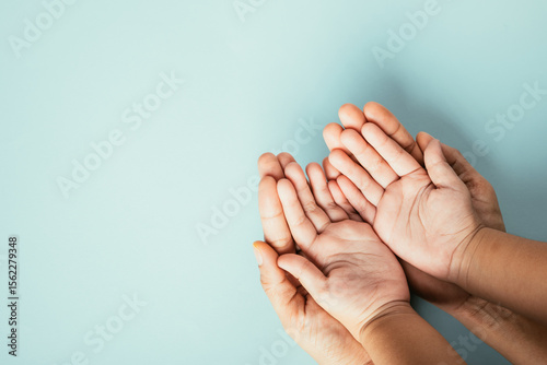 Family hands stack in close-up top view isolated background. Parents and child hold empty space together expressing support on Family and Parents Day.