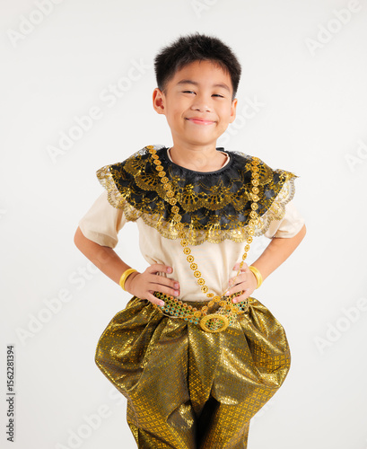 Portrait of Thailand kid boy smiling traditional Thai dress costume stand akimbo gesture in studio shot isolated white background, Happy primary child standing on waist support