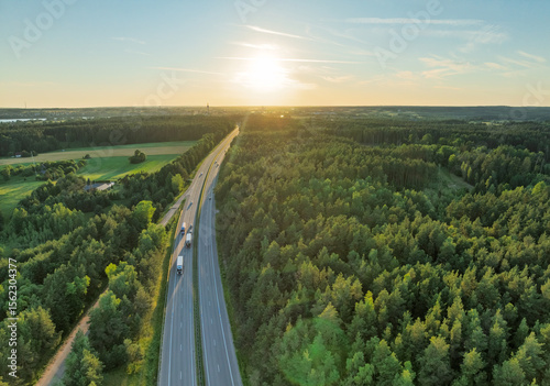 Aerial View of a Scenic Highway Surrounded by Lush Forest During Sunset