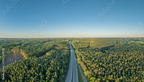 Photos Scenic Aerial Drone View of a Forested Landscape with Highway Under Clear Blue S