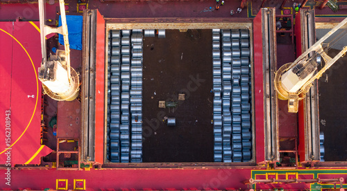 A bulk carrier freight ship at Loading steel coils at the port. Aerial view drone photo 