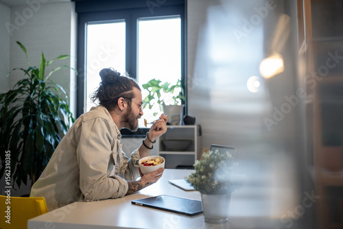 Freelancer enjoying breakfast and working from home office