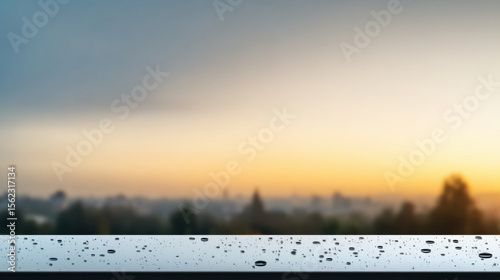 Serene view of blurred cityscape at twilight with focus on water droplets on reflective surface in foreground, evoking calm and introspection
