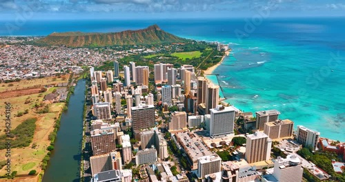 Sunny scenery of a beautiful Waikiki resort on the shore of the Pacific Ocean. Aerial perspective on the Ala Wai Canal and the Diamond Head Crater.