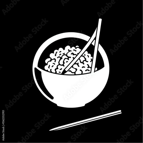 A pair of chopsticks beside a rice bowl