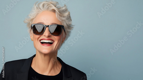 A woman wearing sunglasses and smiling