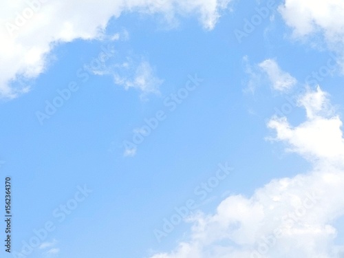 Sky and cloud gradient background. A very bright, dramatic blue sky covered in wisps of soft, wispy clouds against the backdrop of a peaceful daytime scene. The sun was shining hot.