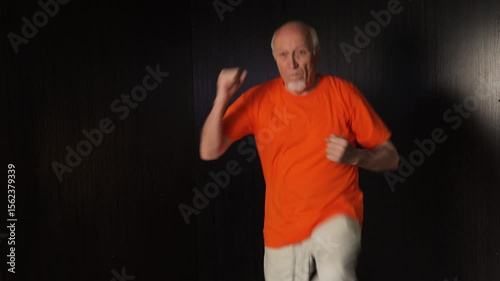 Old male athlete performing elbow to knee touches in a jump