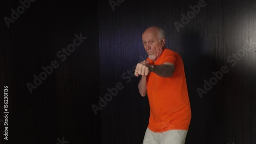 Old male athlete trains his jumping stance and punches