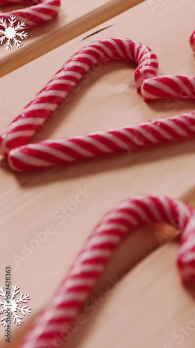 Animation of snow falling over christmas candy canes