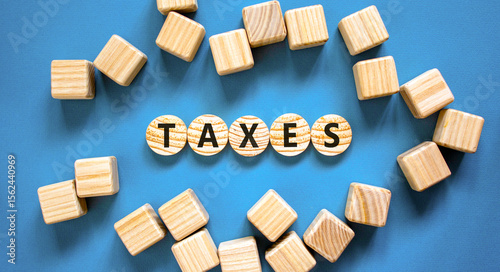 Taxes symbol. Concept word Taxes on beautiful wooden circles. Beautiful blue table blue background. Beautiful wooden cubes. Business lifestyle taxes concept. Copy space.