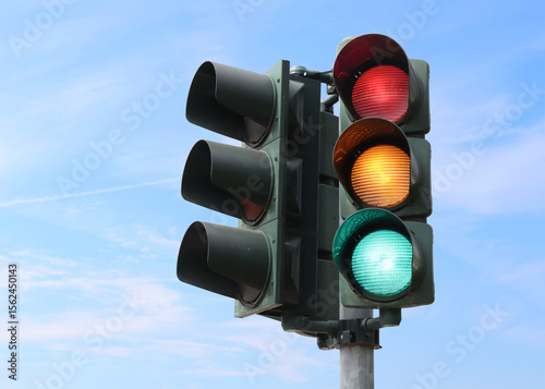 Traffic light with all lights on with the sky as background