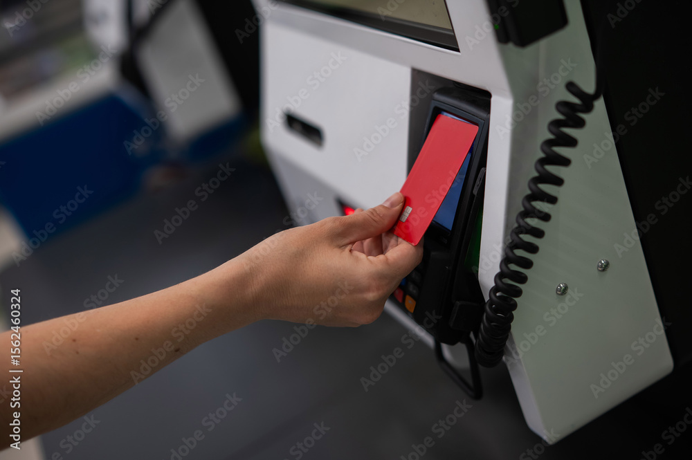 Obraz premium Woman paying with credit card at self-checkout. 