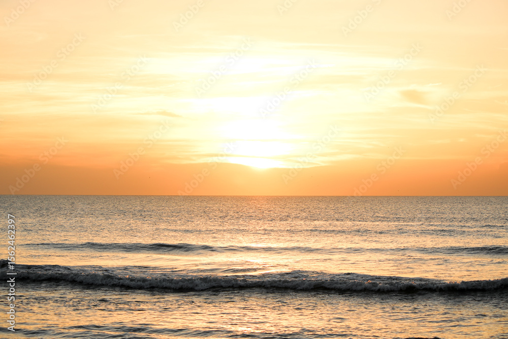 Fototapeta premium Golden Sunrise Over the Calm Florida Ocean Horizon With Gentle Waves