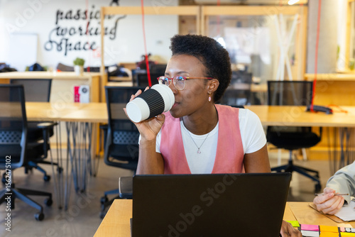 Woman working in modern office with coffee cup photo