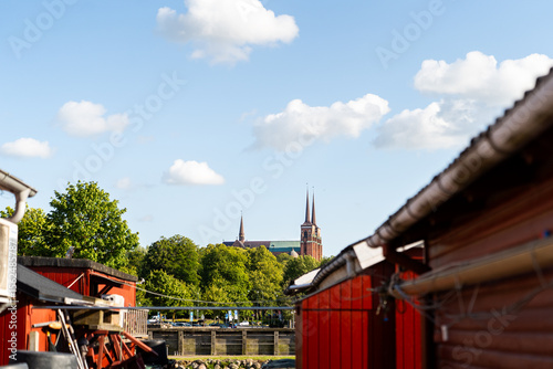 Roskilde Cathedral Spires Peeking Over Red Boathouses