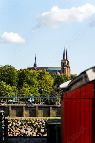 Roskilde Cathedral Spires Peeking Over Red Boathouses