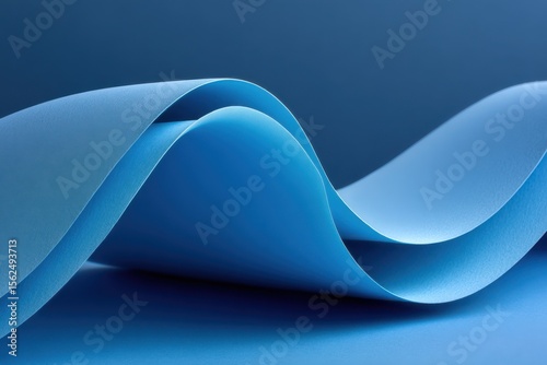 Curved blue layers create a serene visual experience under soft lighting in an artistic studio setting