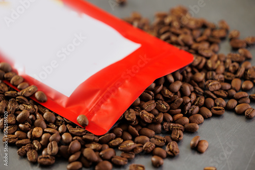 Roasted coffee beans spilling from red bag in factory setting