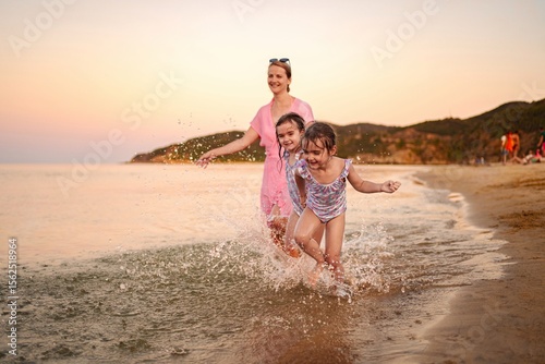 Joyful family moments splashing near the shore at sunset