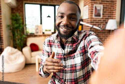 Pov of self employed black man creating video content for online viewers, sharing business investment ideas. Happy remote worker holding phone camera and virtually speaking with colleagues from home.