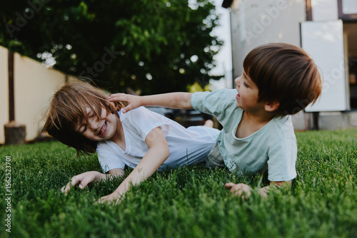 Joyful children playing outside on a sunny day, enjoying their time together on the green grass, smiling and laughing, creating happy memories. ###