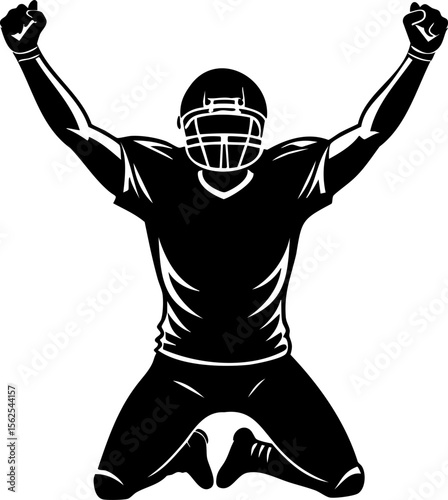 Football player celebrating with arms raised, wearing helmet and uniform, kneeling on ground