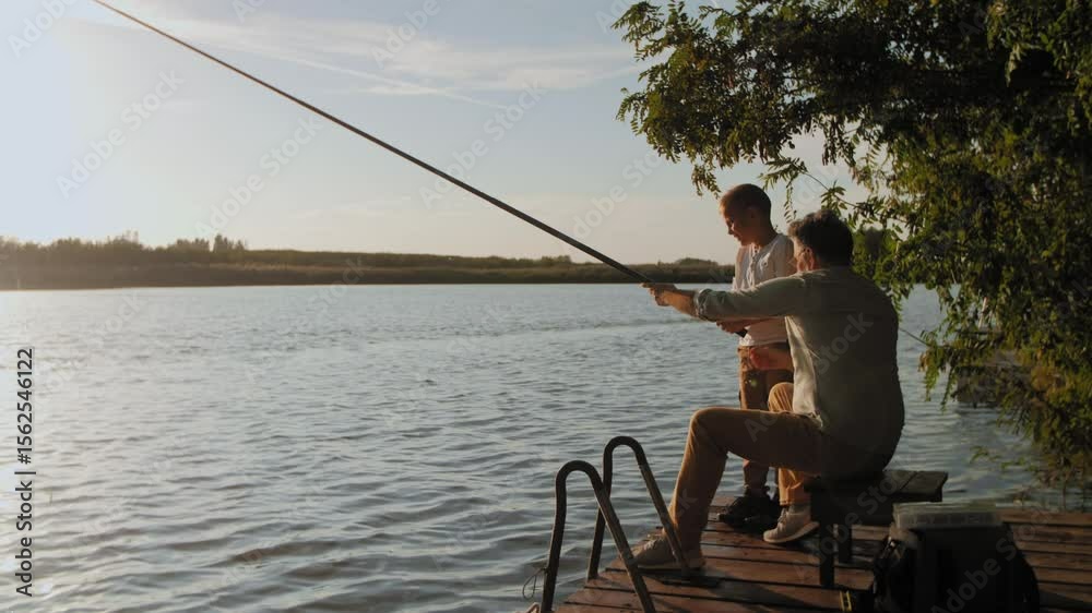 Father and son fishing together on a lake Father and son fishing together on a lake
