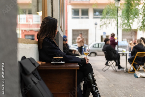 Pensive woman drinking whine at street cafe