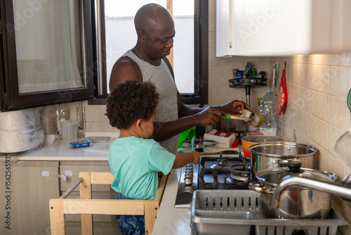 Congolese father cooking with his son help him in the kitchen