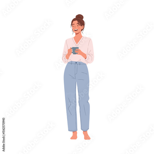 A smiling woman with a bun hairstyle is holding a cup, wearing a white shirt and blue jeans.