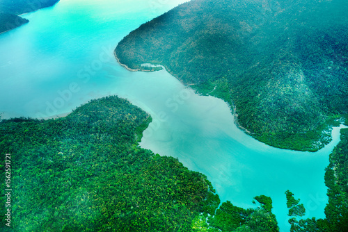 Fototapeta Naklejka Na Ścianę i Meble -  Aerial view of submerged reefs (green color) and surface clear waters (blue color) at Great Barrier Reef, the world's largest coral reef system in the Coral Sea near Whitsunday Island. Australia. 2020