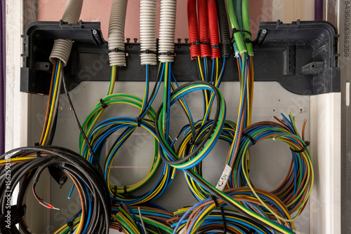 Inside of an home electricity breaker box with many colorful wires photo