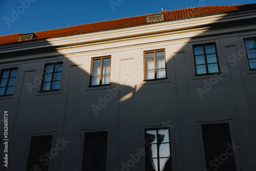Building facade with dramatic shadow and window reflections
