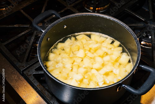 Chopped up potatoes boiling on stovetop