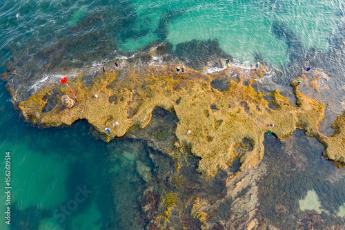 Fishermen on a rock platform surrounded by the sea