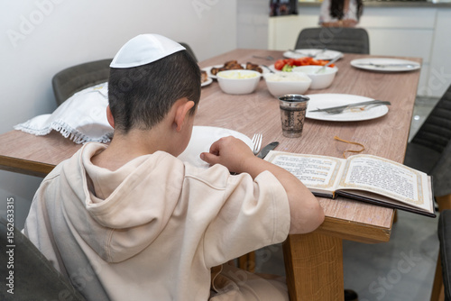 Child praying at Shabbat table before festive meal